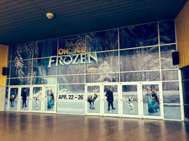 Large-scale multi-piece window cut display covers the windows and door entry to an arena.